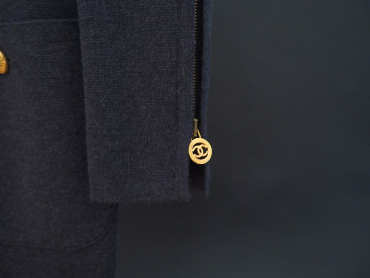 	CHANEL Robe grise en laine à manches longues. Un rang de quatre médai