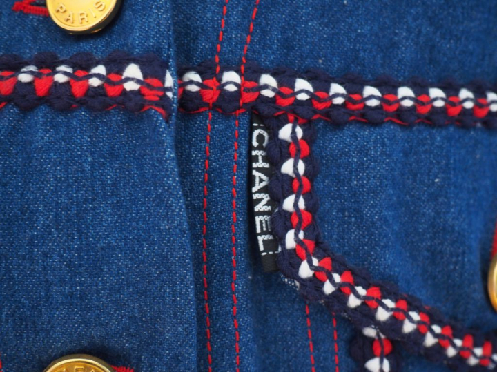 	CHANEL Veste sans manche à col en coton, à décor d’un galon bleu, bla