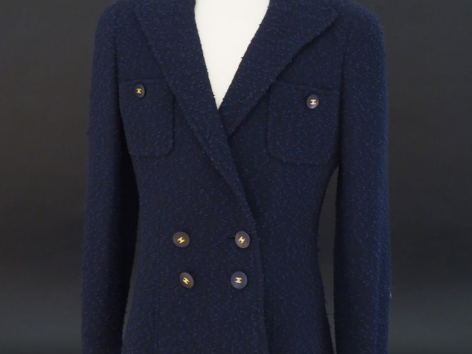 CHANEL Veste courte à col bleu marine. Deux poches au niveau de la poi