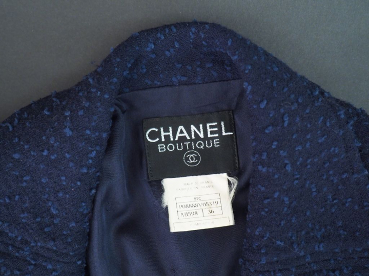 CHANEL Veste courte à col bleu marine. Deux poches au niveau de la poi