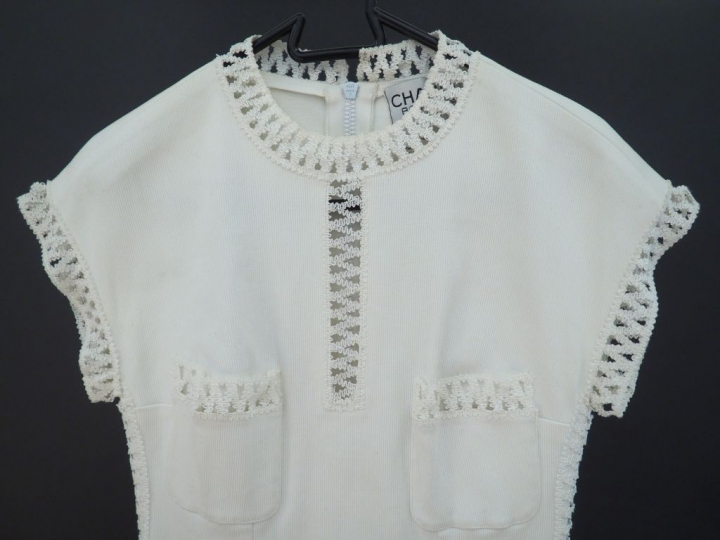 CHANEL Robe sans manche blanche. Col, manches, poches et cotés de la r
