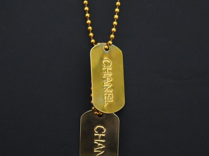 	CHANEL Sautoir en métal doré, à décor de boules retenant deux plaques