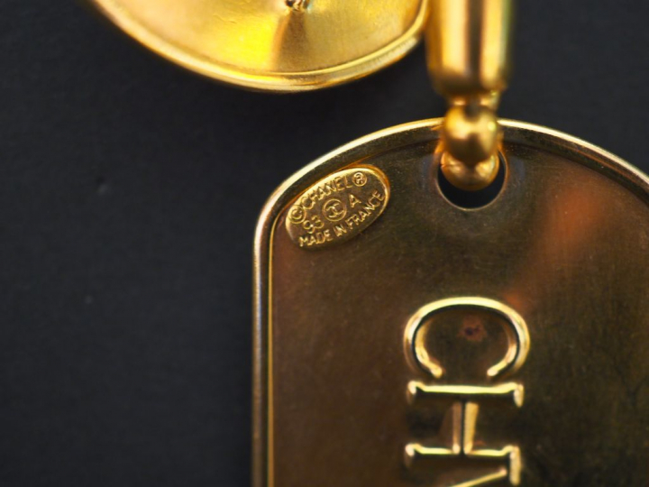 	CHANEL Sautoir en métal doré, à décor de boules retenant deux plaques