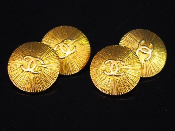 	CHANEL. Paire de boutons de manchettes en métal doré, à décor du mono