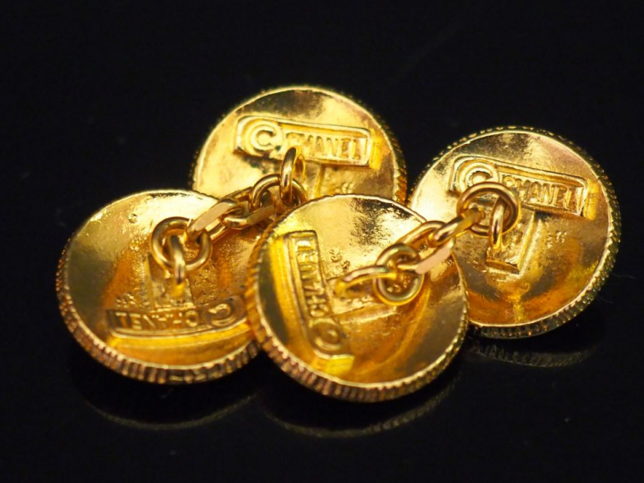 	CHANEL. Paire de boutons de manchettes en métal doré, à décor du mono