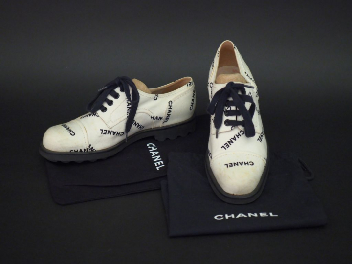 	CHANEL Paire de richelieus en tissu blanc, à décor en noir du nom de 