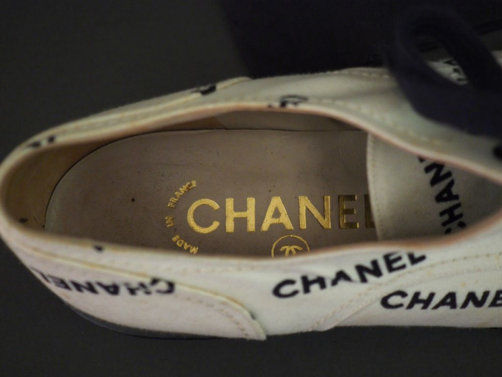 	CHANEL Paire de richelieus en tissu blanc, à décor en noir du nom de 