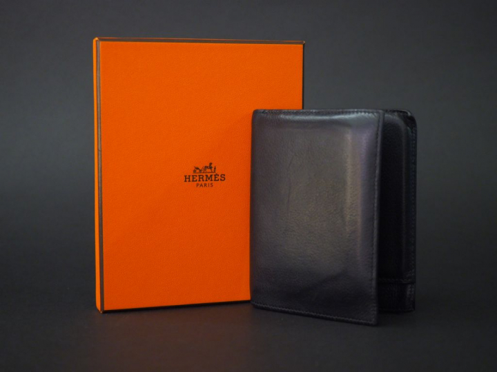 	HERMES, Paris. Portefeuilles en cuir noir.  Signé. 12 x 9.4 cm  Dans 
