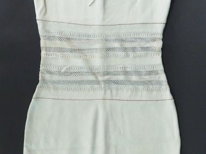 ALAÏA.  Robe fourreau ajourée de couleur ivoire. Fermeture éclair au d