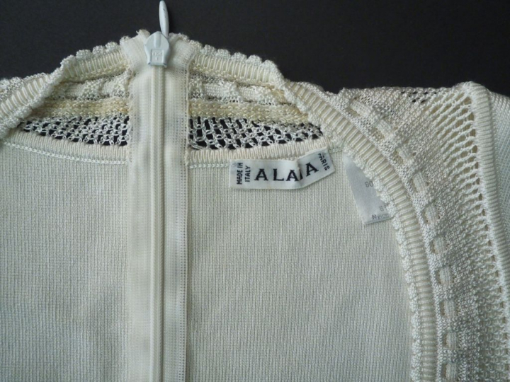 ALAÏA.  Robe fourreau ajourée de couleur ivoire. Fermeture éclair au d