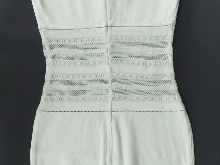 ALAÏA.  Robe fourreau ajourée de couleur ivoire. Fermeture éclair au d