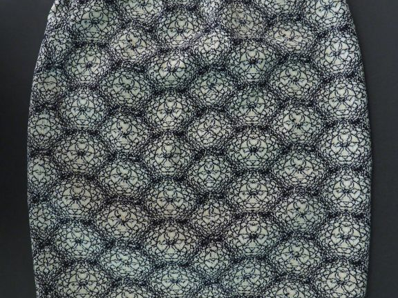 ALAÏA. Mini jupe en maille dans les tons noir et blanc, à décor de fle