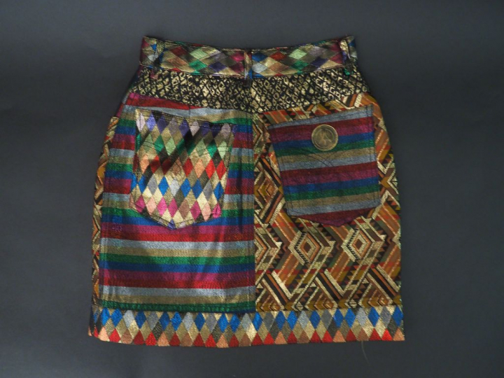 MOSCHINO Mini-jupe en tissu bariolé et pailleté. Ouverture à l’avant a