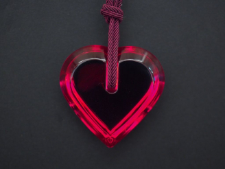 Vente aux enchères 	BACCARAT Pendentif en forme de coeur en cristal rouge, retenu par un 