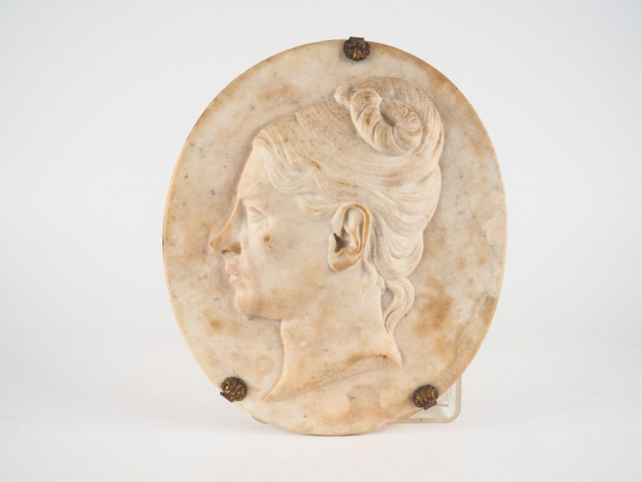 ROMAND. Plaque ovale en albâtre sculpté figurant un profil de jeune fe