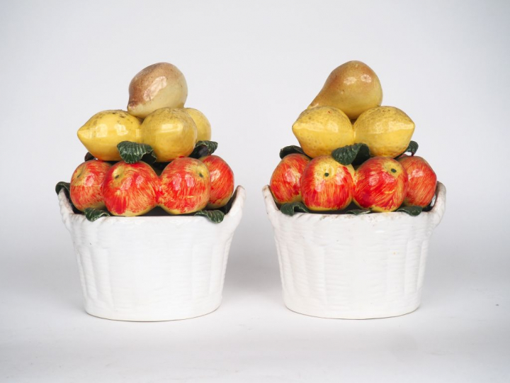 Paire de corbeilles de fruits en trompe l'œil en céramique polychrome.