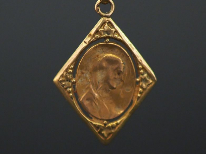 Médaille religieuse en or jaune forme de losange, à  décor ajouré, fig