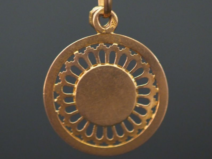 Petite médaille religieuse en or jaune ajouré, à  décor d’un angelot. 