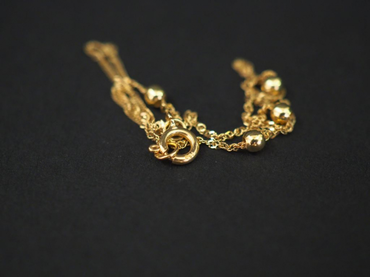 Petit bracelet en or jaune, à décor de quatre boules. Long. 17,5 cm Po