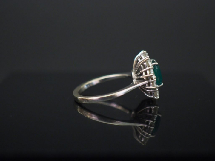 Bague marguerite en or blanc, sertie en son centre d’une émeraude ento