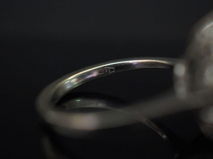 Bague marguerite en or blanc, sertie en son centre d’une émeraude ento