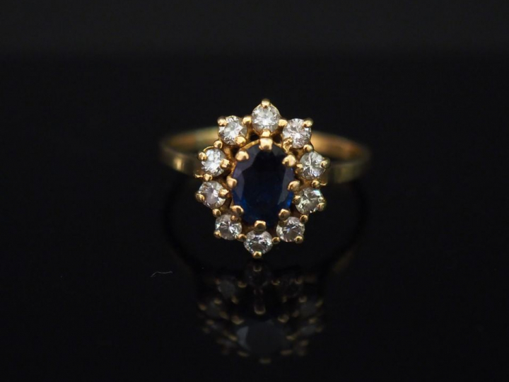 	Bague marguerite en or jaune, sertie en son centre d’un saphir entour