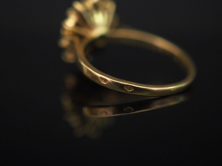 	Bague marguerite en or jaune, sertie en son centre d’un saphir entour