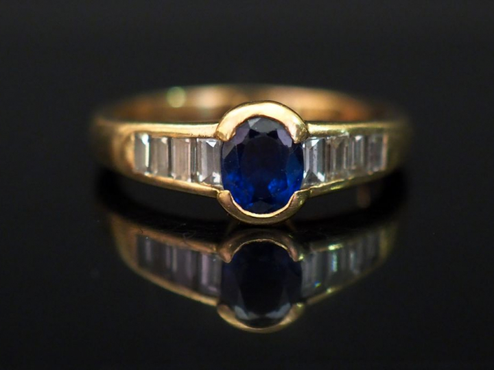 Bague jonc en or jaune, sertie en son centre d’un saphir épaulé de hui