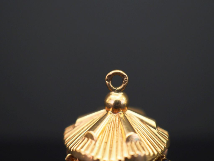 	Pendentif en or jaune, en forme de case, à décor de filigranes, de pi
