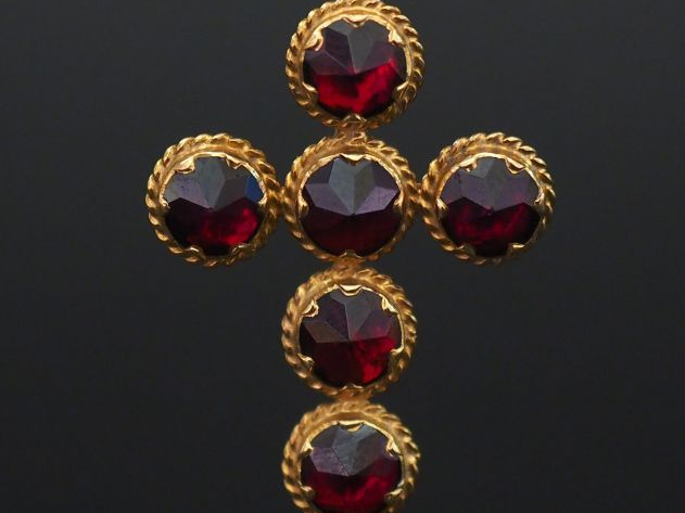 Pendentif en or jaune en forme de croix, sertie de six grenats. 3,4 x 