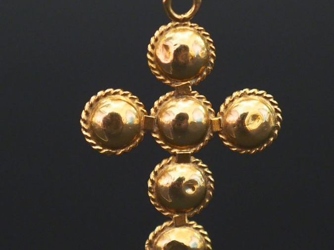 Pendentif en or jaune en forme de croix, sertie de six grenats. 3,4 x 