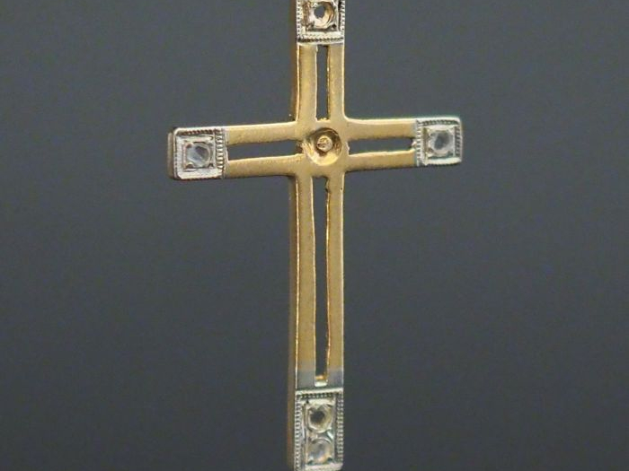Pendentif ajouré en forme de croix en or jaune.  Les extrémités sertie