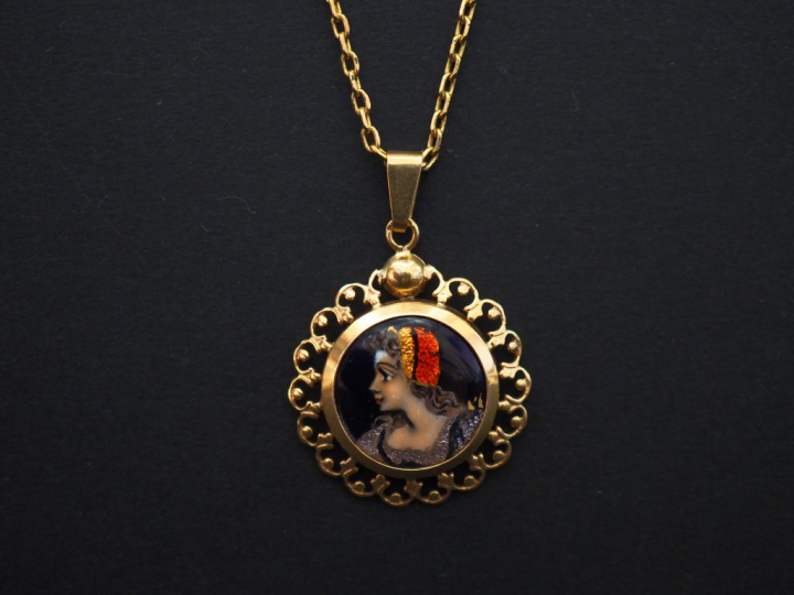 	Pendentif en or jaune, serti en son centre d’un émail, à décor polych