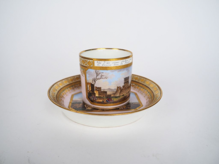 Tasse et sous-tasse en porcelaine de Vienne à décor polychrome de pays