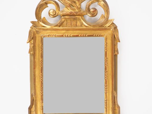 Miroir de style Louis XVI en bois doré, fronton ajouré à décor de trop