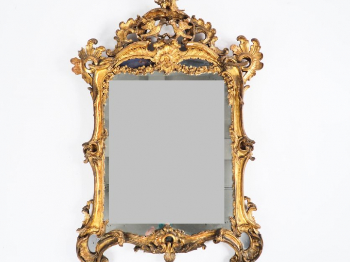 Glace Louis XV de style rocaille en bois sculpté et doré à décor de pa