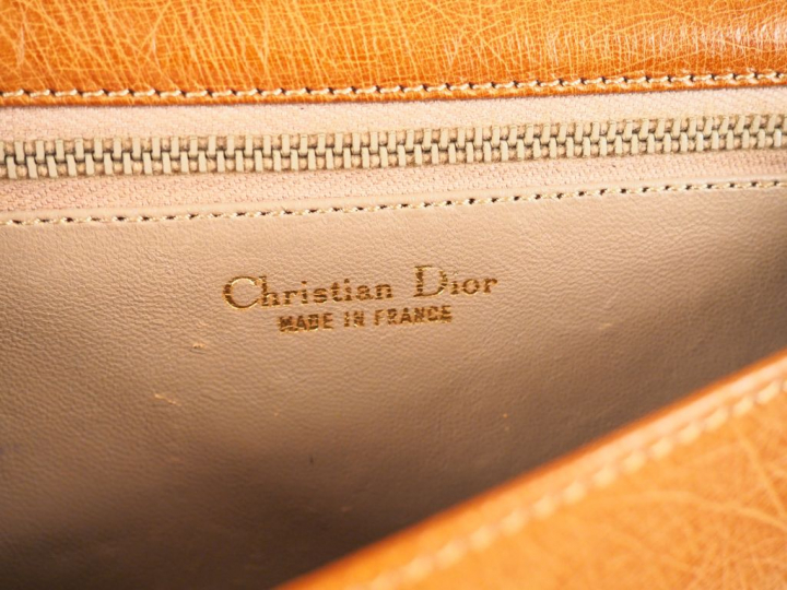 Christian DIOR. Petit sac à main en cuir gaufré marron. Signé.