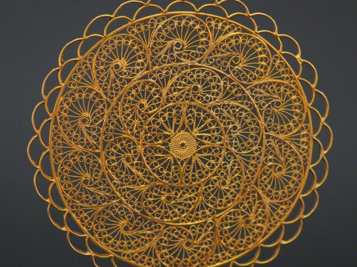 Grand pendentif circulaire en or jaune, à décor ajouré et filigrané.  