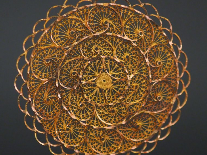 Grand pendentif circulaire en or jaune, à décor ajouré et filigrané.  