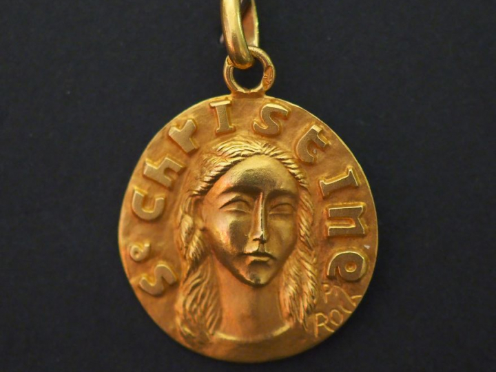 Médaille religieuse en or jaune, figurant Sainte Christine.  Diam. 1,8