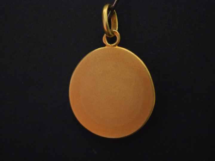 Médaille religieuse en or jaune, figurant Sainte Christine.  Diam. 1,8