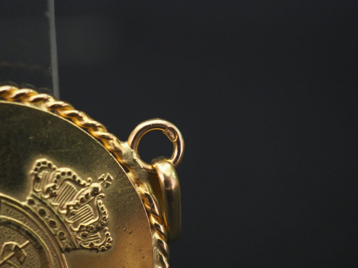Pendentif en or jaune, serti en son centre d'une médaille d'un tournoi