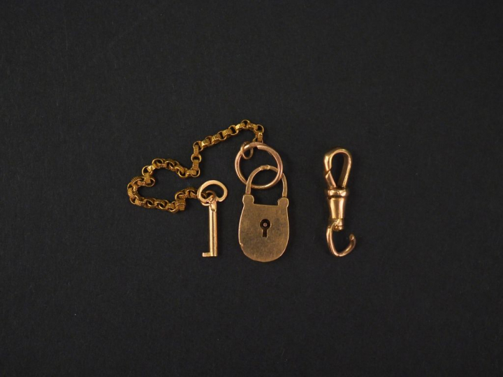 Ensemble comprenant :  - un cadenas et sa clé en or jaune. -	 un éléme