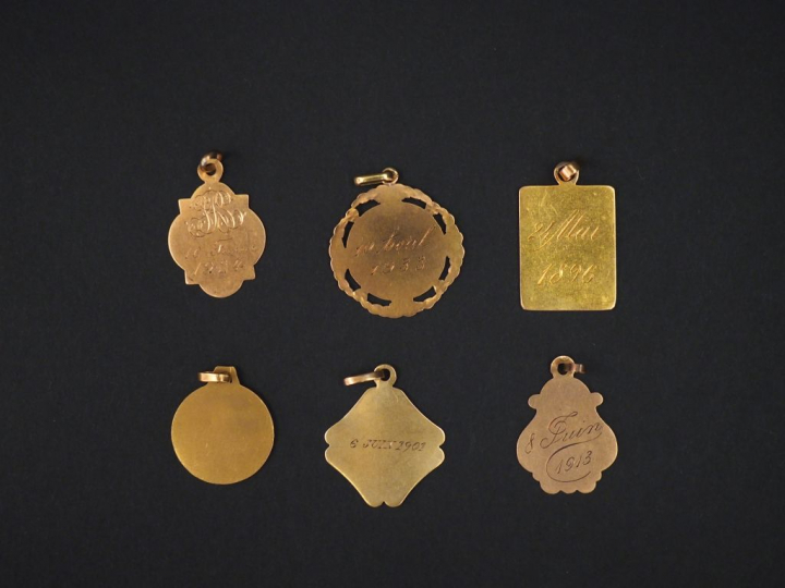 Ensemble comprenant cinq différentes médailles en or jaune, à décor de