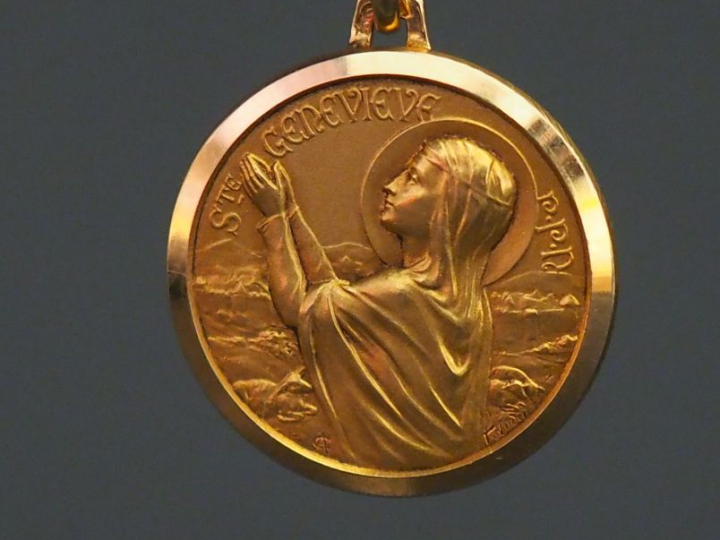 Médaille religieuse en or jaune, figurant Sainte Geneviève.  Diam. 1,8