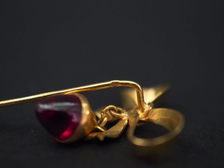 Ensemble comprenant :  - une épingle en or jaune en forme de nœud de r