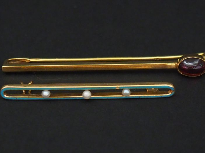 Ensemble comprenant :  - une broche barrette en or jaune, sertie d'un 