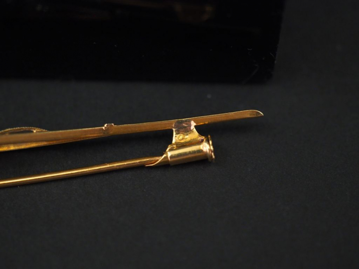 Ensemble comprenant :  -	une broche barrette en or jaune, formée de de