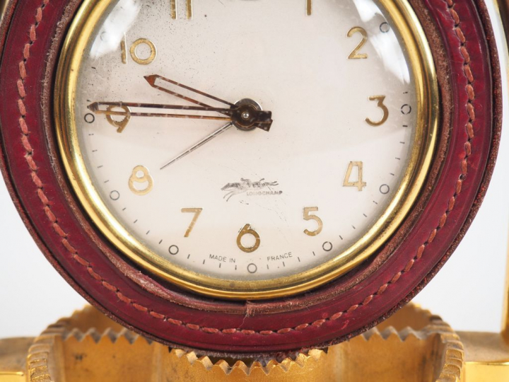 LONGCHAMP.  Pendulette en bronze et cuir en forme d'éperon.  Dim. 18 x