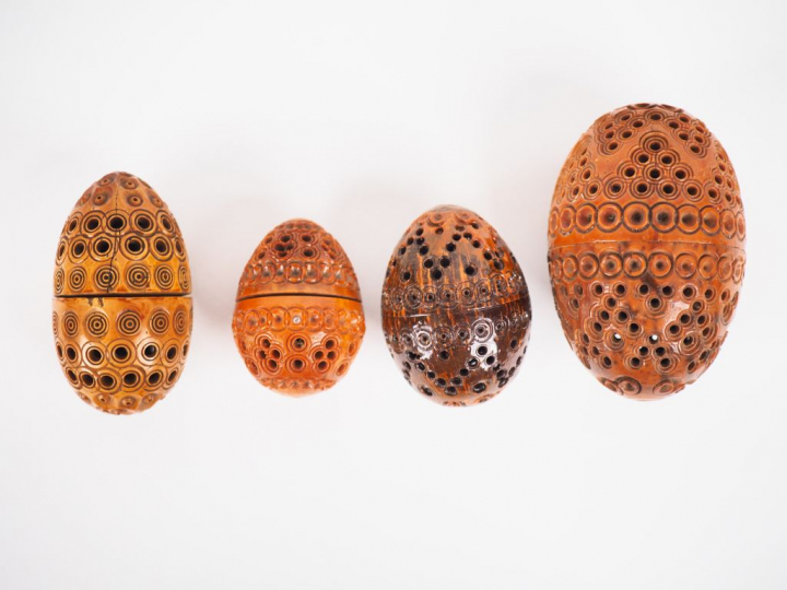 Quatre différents œufs à chapelet en corozo sculpté.